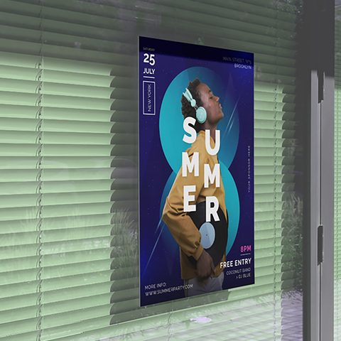 A summer event poster displayed in a shop window